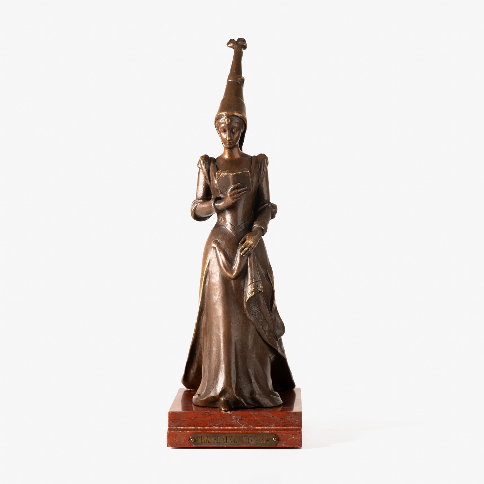 Art Nouveau bronze and red marble sculpture “Châtelaine XIV S”. Beautiful Art Nouveau bronze sculpture titled “Châtelaine XIV S”, 14th century Lady of the castle. It depicts a Lady of the Middle Ages with headdress and long-tailed dress walking absorbed reading a book. She stands on a stepped pedestal of red marble