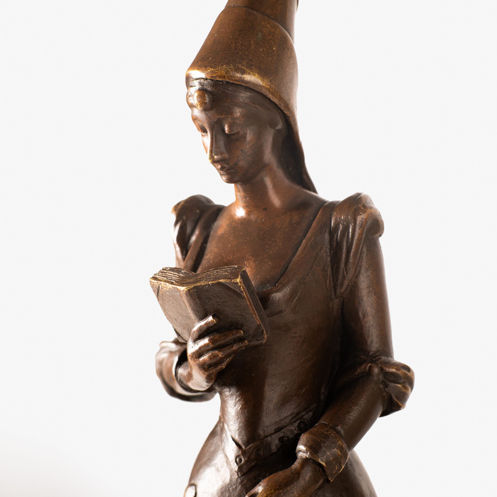 Art Nouveau bronze and red marble sculpture “Châtelaine XIV S”. Beautiful Art Nouveau bronze sculpture titled “Châtelaine XIV S”, 14th century Lady of the castle. It depicts a Lady of the Middle Ages with headdress and long-tailed dress walking absorbed reading a book. She stands on a stepped pedestal of red marble