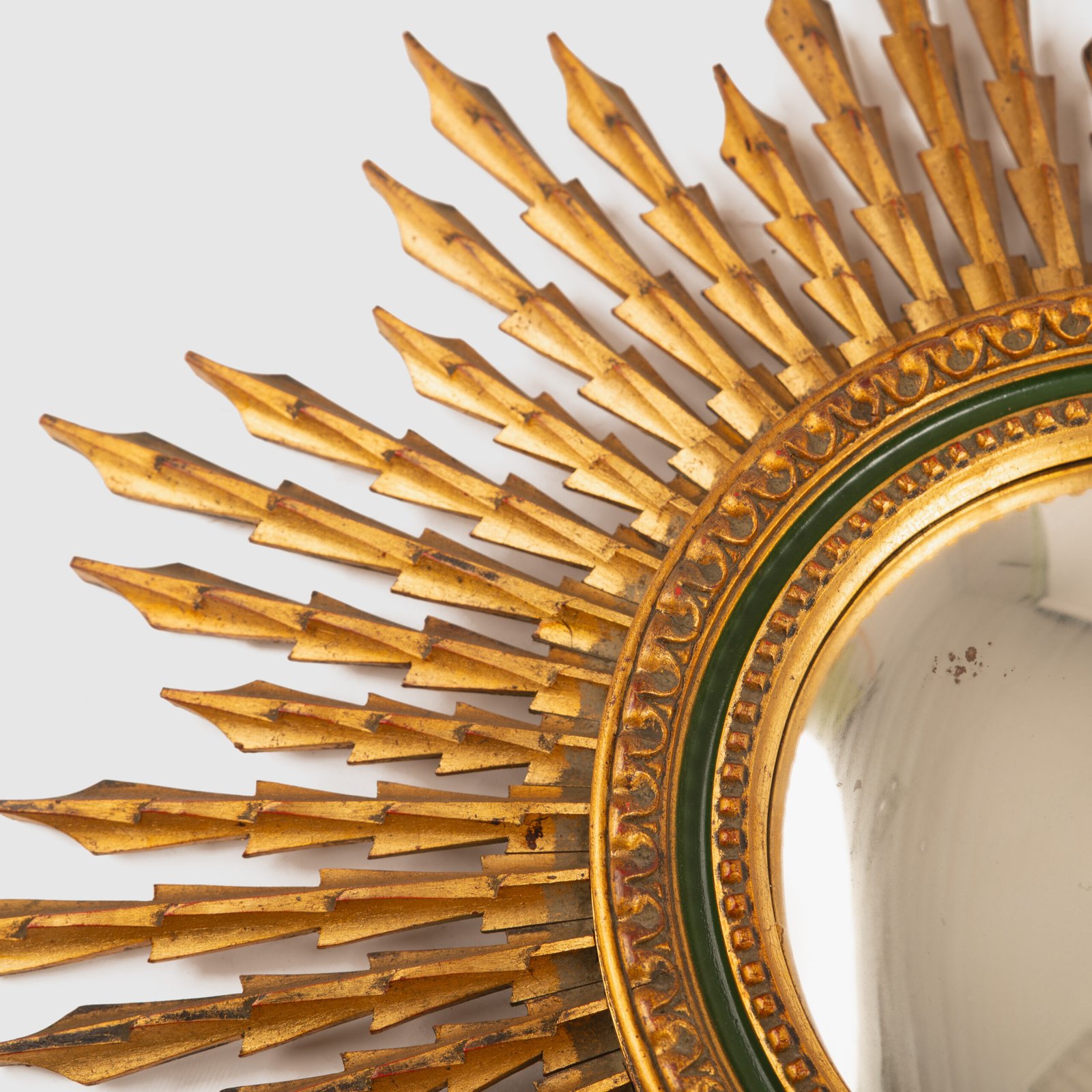 Portuguese Sunburst mirror in gilded carved wood, 1930's. We are pleased to present a splendid Portuguese vintage gilded carved wood sunburst mirror, a unique piece that exudes elegance and sophistication.