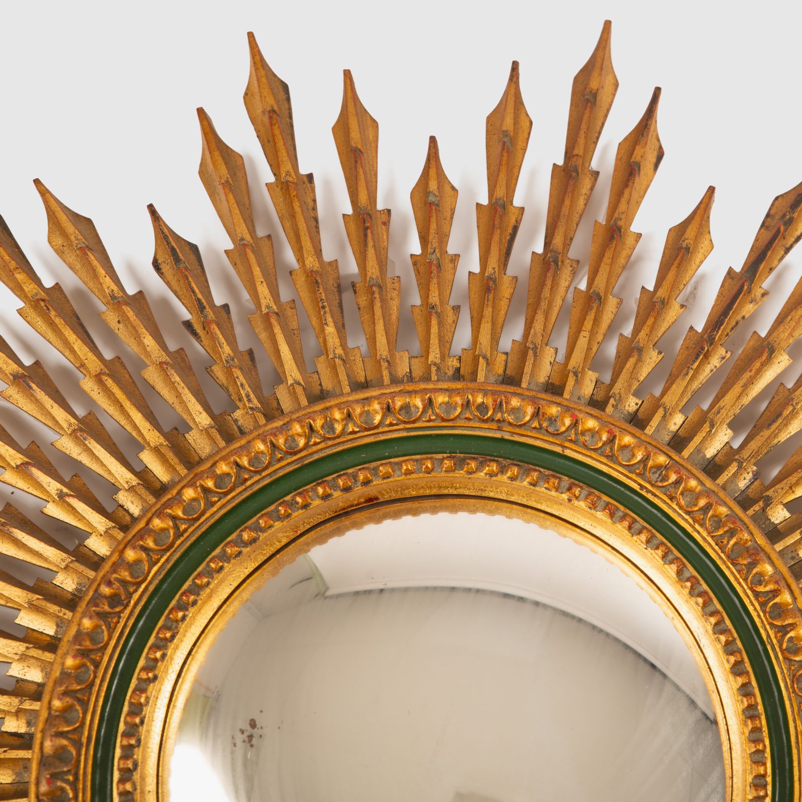 Portuguese Sunburst mirror in gilded carved wood, 1930's. We are pleased to present a splendid Portuguese vintage gilded carved wood sunburst mirror, a unique piece that exudes elegance and sophistication.