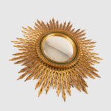 Portuguese Sunburst mirror in gilded carved wood, 1930's. We are pleased to present a splendid Portuguese vintage gilded carved wood sunburst mirror, a unique piece that exudes elegance and sophistication.