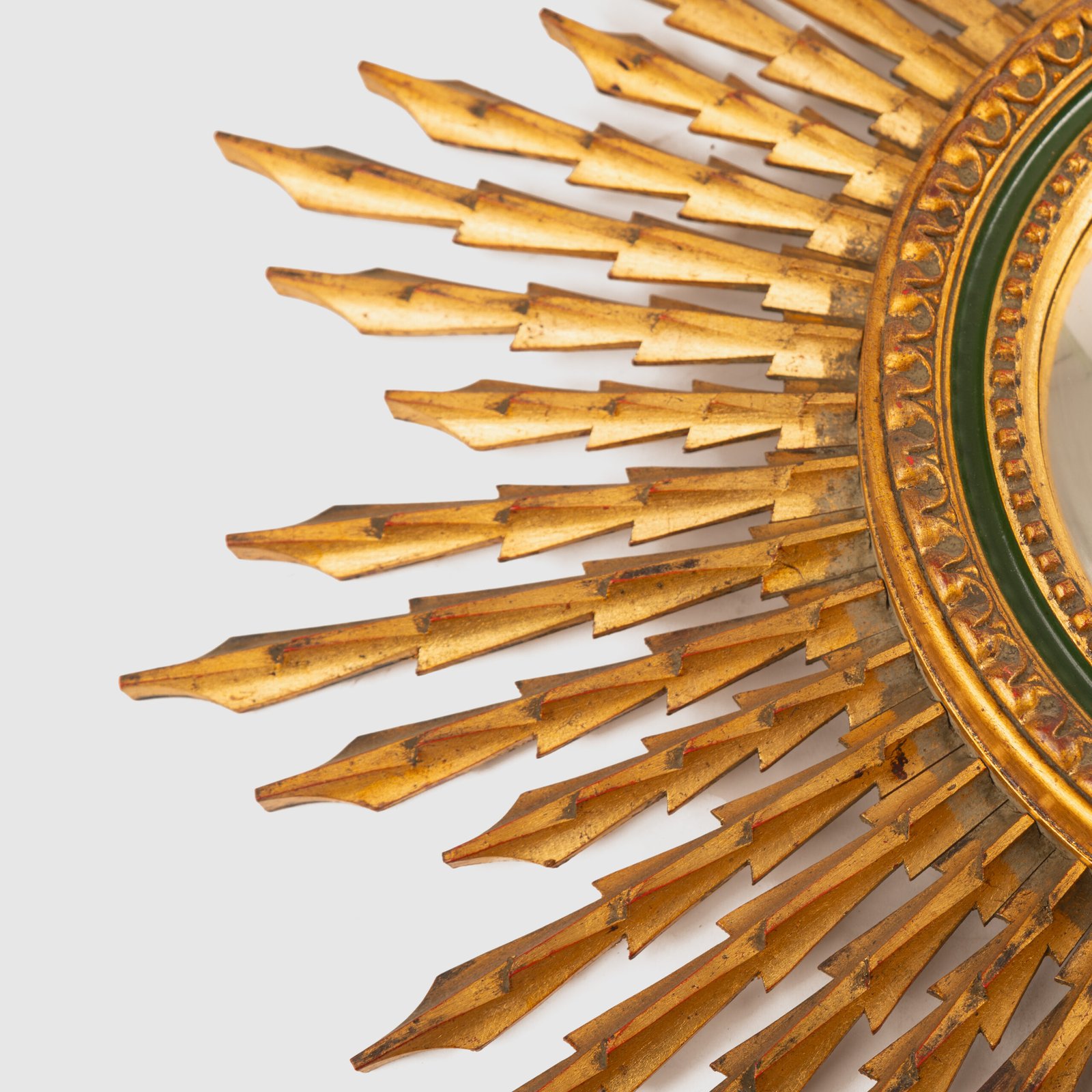 Portuguese Sunburst mirror in gilded carved wood, 1930's. We are pleased to present a splendid Portuguese vintage gilded carved wood sunburst mirror, a unique piece that exudes elegance and sophistication.