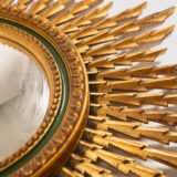 Portuguese Sunburst mirror in gilded carved wood, 1930's. We are pleased to present a splendid Portuguese vintage gilded carved wood sunburst mirror, a unique piece that exudes elegance and sophistication.