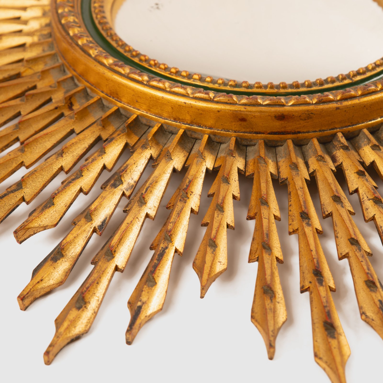 Portuguese Sunburst mirror in gilded carved wood, 1930's. We are pleased to present a splendid Portuguese vintage gilded carved wood sunburst mirror, a unique piece that exudes elegance and sophistication.