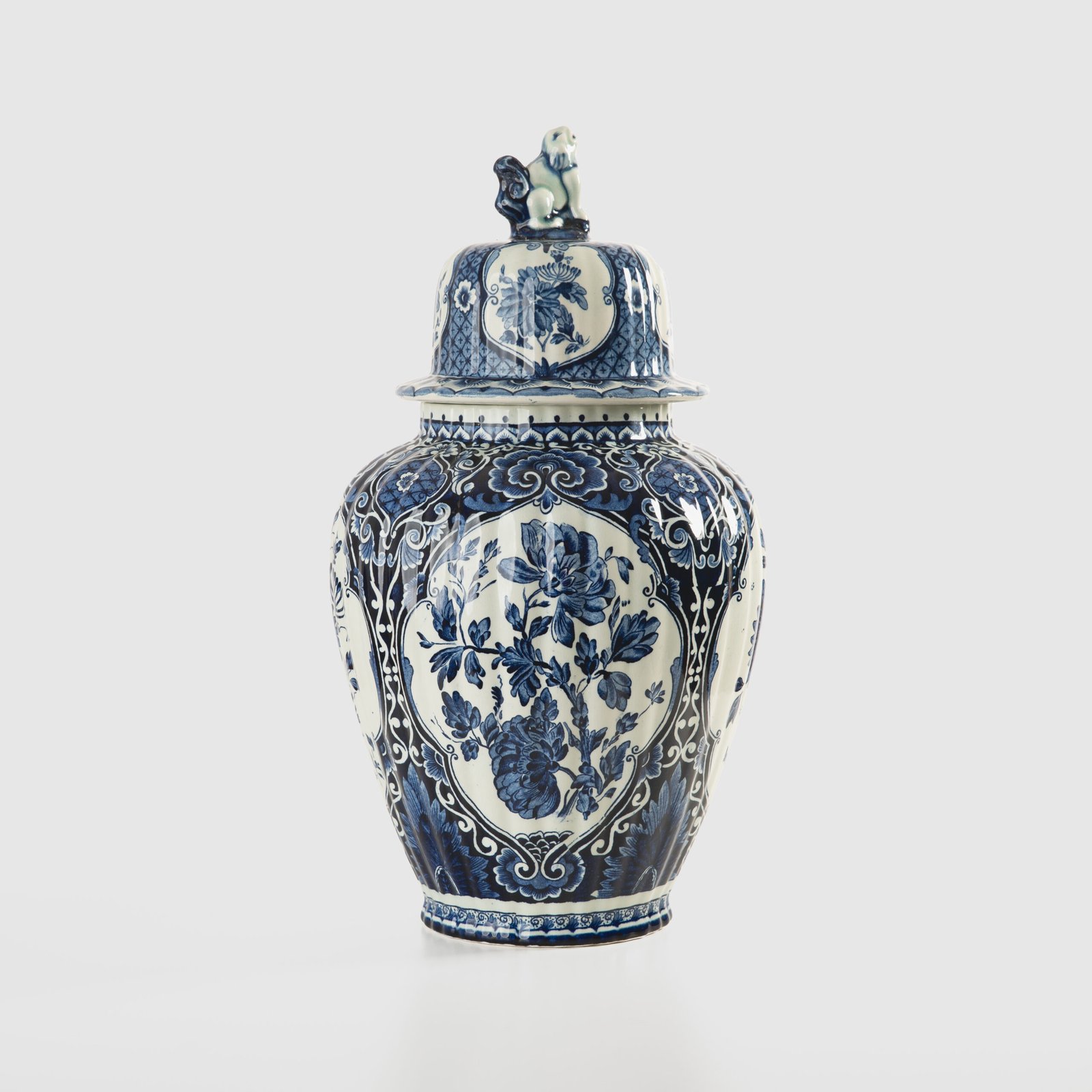 Royal Sphinx Delft-Style Lidded Vase with Foo Dog – Lobed Blue & White Ceramic, Mid-Century A striking mid-century Delft-style lidded vase by Royal Sphinx Maastricht, crafted in the Netherlands around the 1960s. This substantial ceramic piece stands out for its elegant blue and white hand-painted decoration and its rare sculptural Foo Dog finial, blending Dutch ceramic tradition with Orientalist charm.