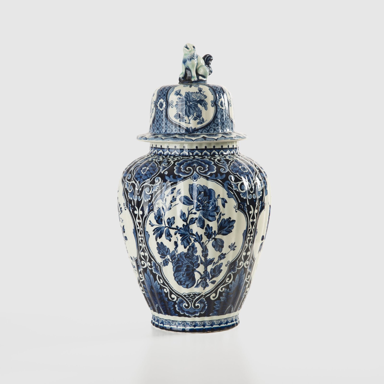 Royal Sphinx Delft-Style Lidded Vase with Foo Dog – Lobed Blue & White Ceramic, Mid-Century A striking mid-century Delft-style lidded vase by Royal Sphinx Maastricht, crafted in the Netherlands around the 1960s. This substantial ceramic piece stands out for its elegant blue and white hand-painted decoration and its rare sculptural Foo Dog finial, blending Dutch ceramic tradition with Orientalist charm.