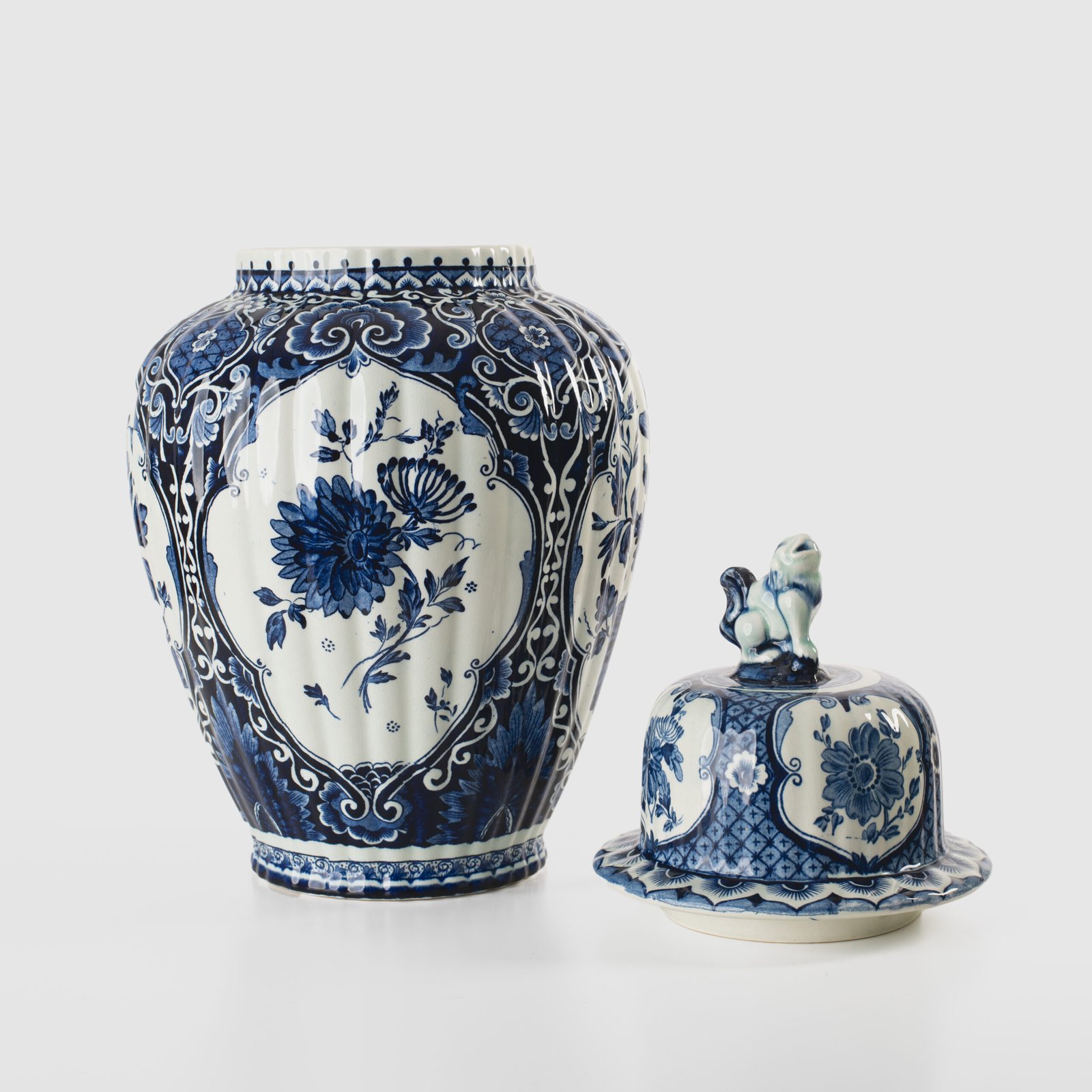 Royal Sphinx Delft-Style Lidded Vase with Foo Dog – Lobed Blue & White Ceramic, Mid-Century A striking mid-century Delft-style lidded vase by Royal Sphinx Maastricht, crafted in the Netherlands around the 1960s. This substantial ceramic piece stands out for its elegant blue and white hand-painted decoration and its rare sculptural Foo Dog finial, blending Dutch ceramic tradition with Orientalist charm.