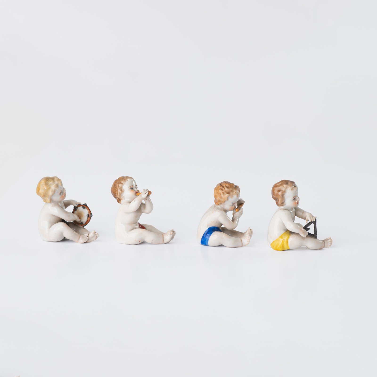 Delicate set of four hand-painted porcelain putti musicians crafted by the Höchst manufactory in Germany, circa 1767–1779. Each figure depicts a different musical instrument and bears the distinctive Höchst wheel mark with radiating spokes. Approx. 1.77 × 1.77 × 1.18 in. A fine example of late Rococo artistry.