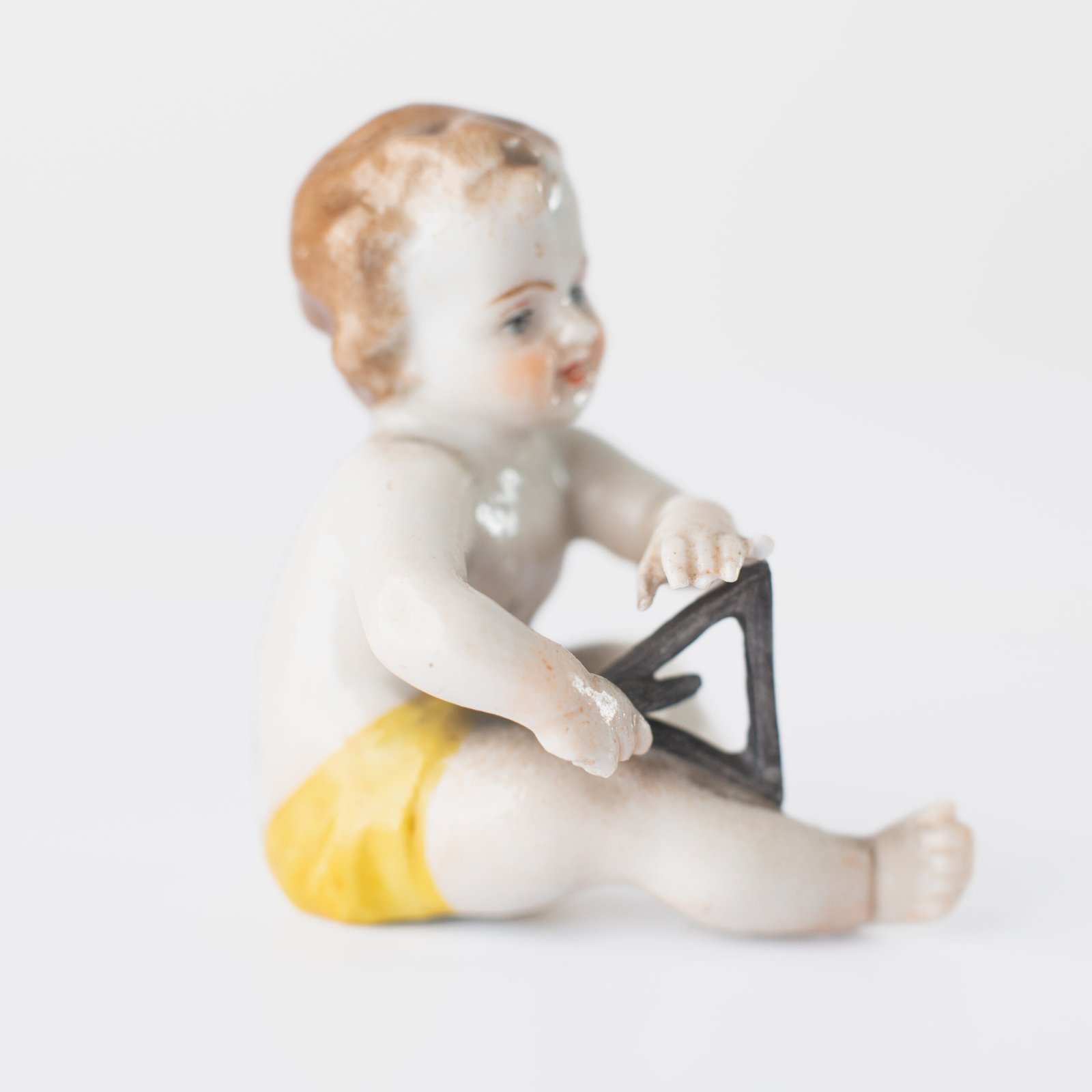 Delicate set of four hand-painted porcelain putti musicians crafted by the Höchst manufactory in Germany, circa 1767–1779. Each figure depicts a different musical instrument and bears the distinctive Höchst wheel mark with radiating spokes. Approx. 1.77 × 1.77 × 1.18 in. A fine example of late Rococo artistry.