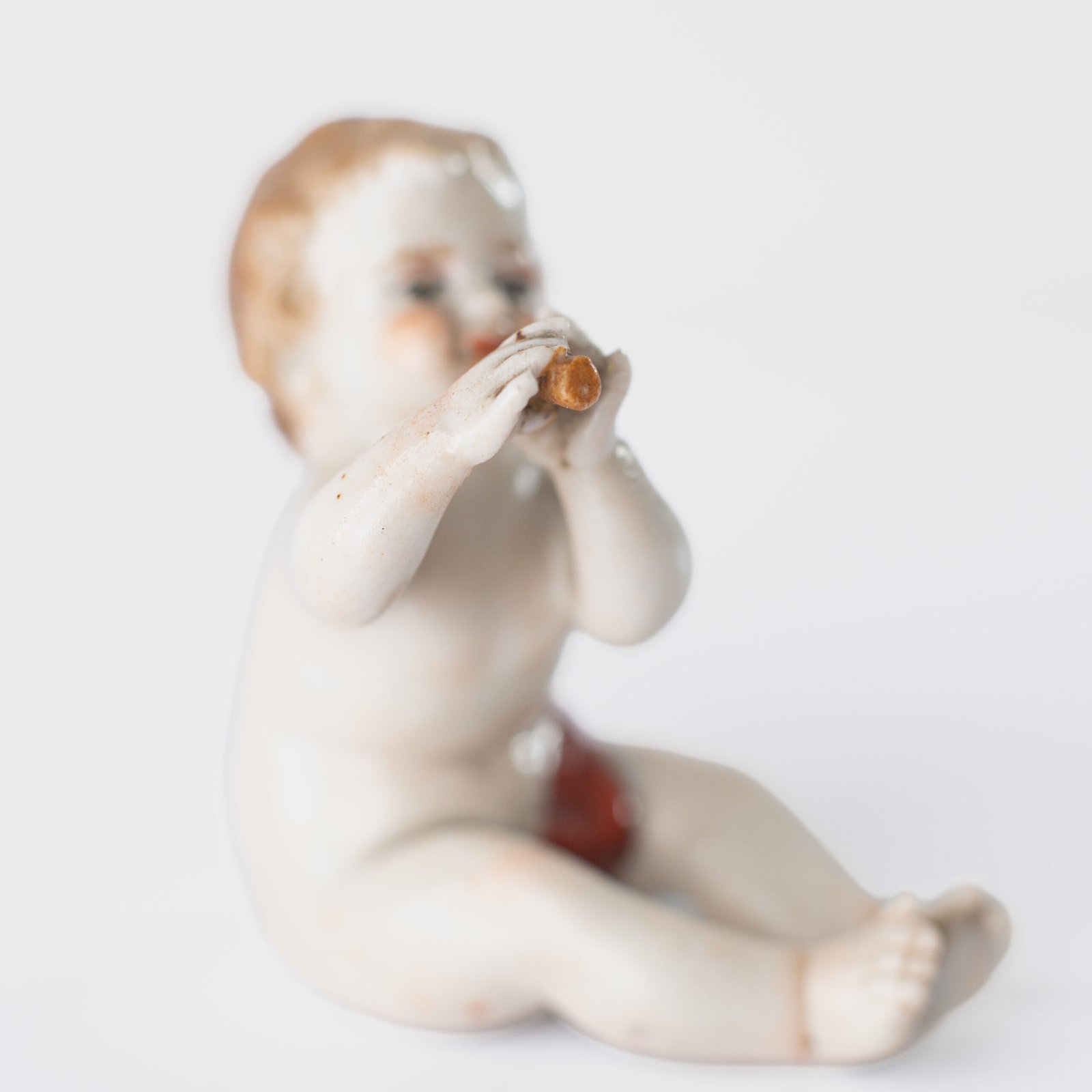 Delicate set of four hand-painted porcelain putti musicians crafted by the Höchst manufactory in Germany, circa 1767–1779. Each figure depicts a different musical instrument and bears the distinctive Höchst wheel mark with radiating spokes. Approx. 1.77 × 1.77 × 1.18 in. A fine example of late Rococo artistry.