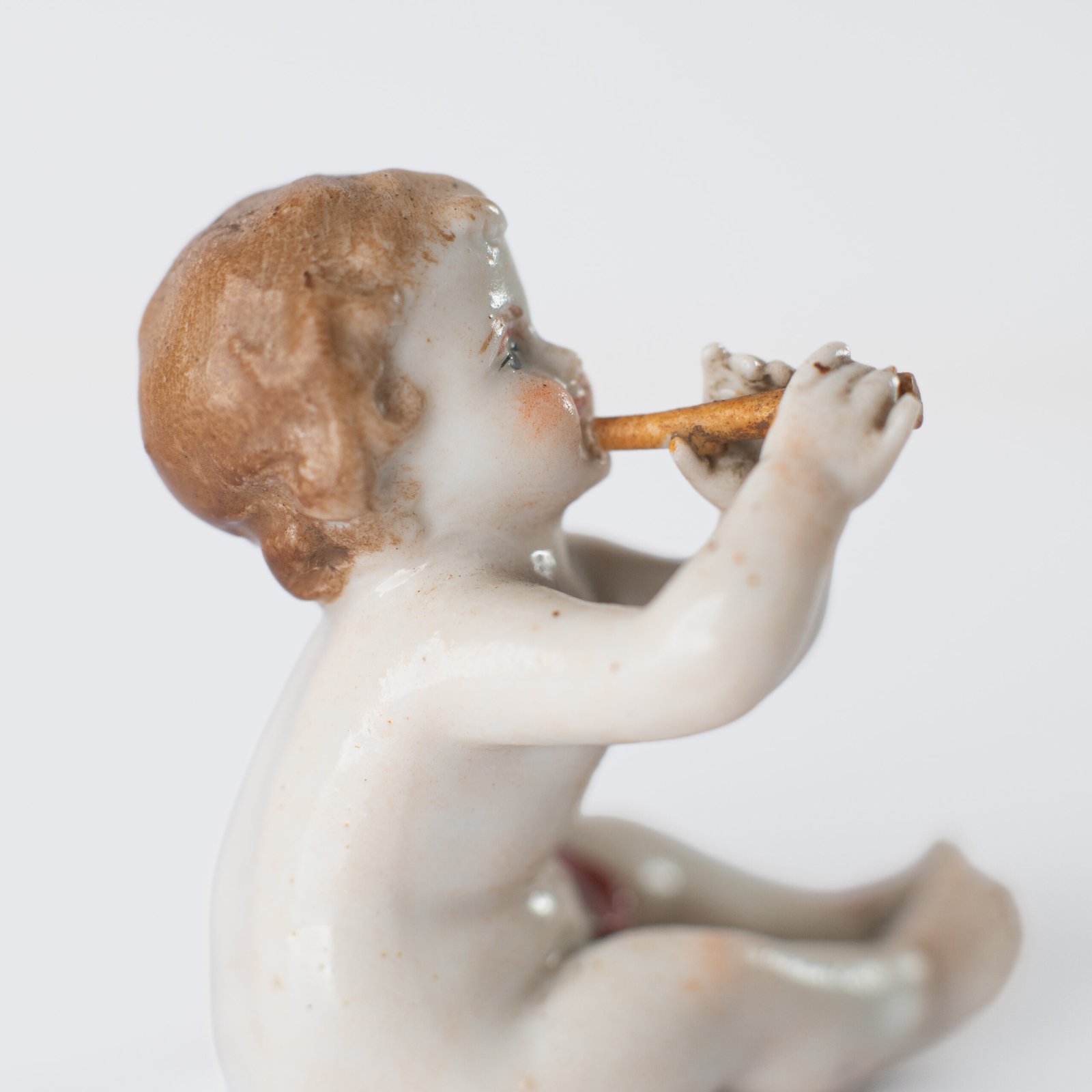 Delicate set of four hand-painted porcelain putti musicians crafted by the Höchst manufactory in Germany, circa 1767–1779. Each figure depicts a different musical instrument and bears the distinctive Höchst wheel mark with radiating spokes. Approx. 1.77 × 1.77 × 1.18 in. A fine example of late Rococo artistry.