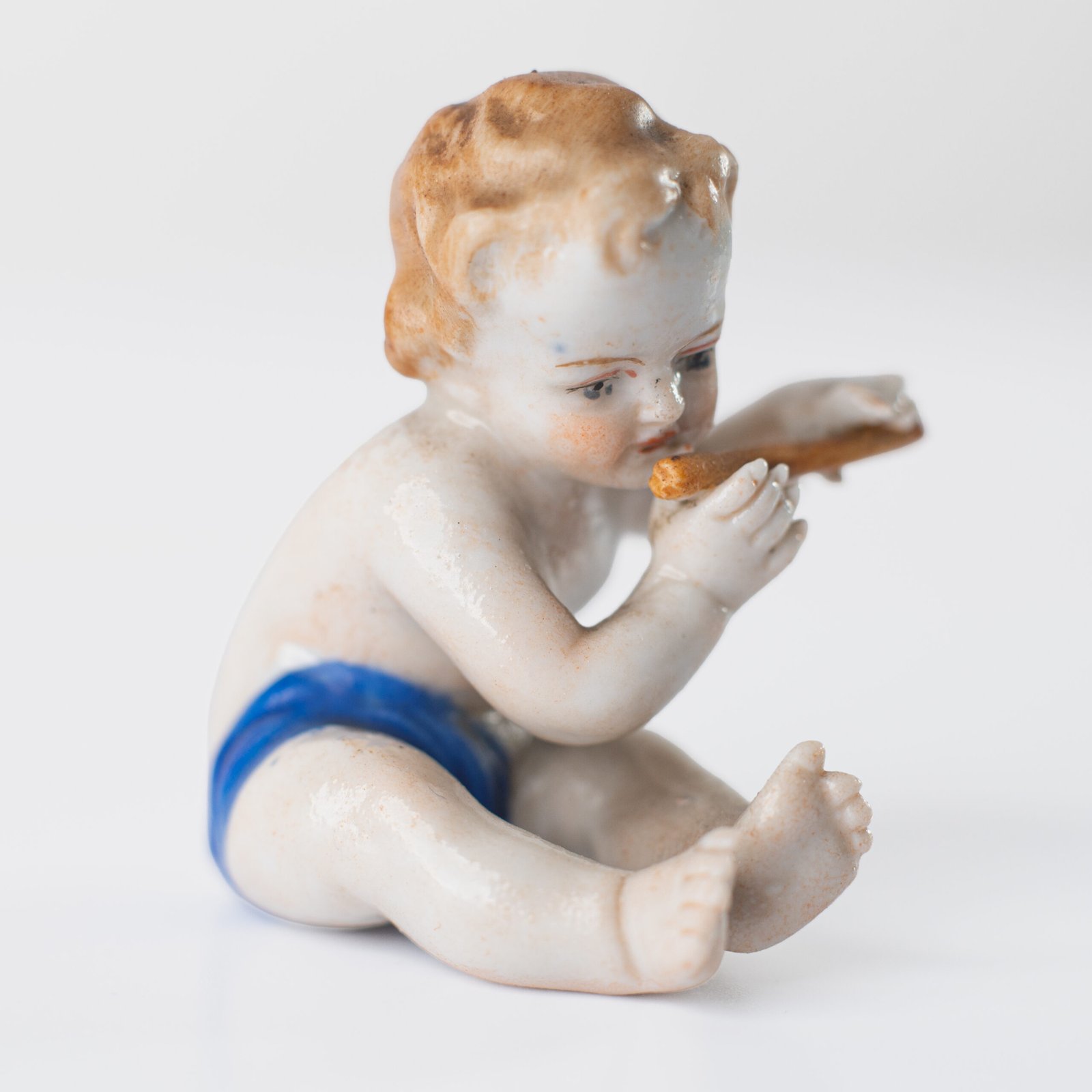 Delicate set of four hand-painted porcelain putti musicians crafted by the Höchst manufactory in Germany, circa 1767–1779. Each figure depicts a different musical instrument and bears the distinctive Höchst wheel mark with radiating spokes. Approx. 1.77 × 1.77 × 1.18 in. A fine example of late Rococo artistry.