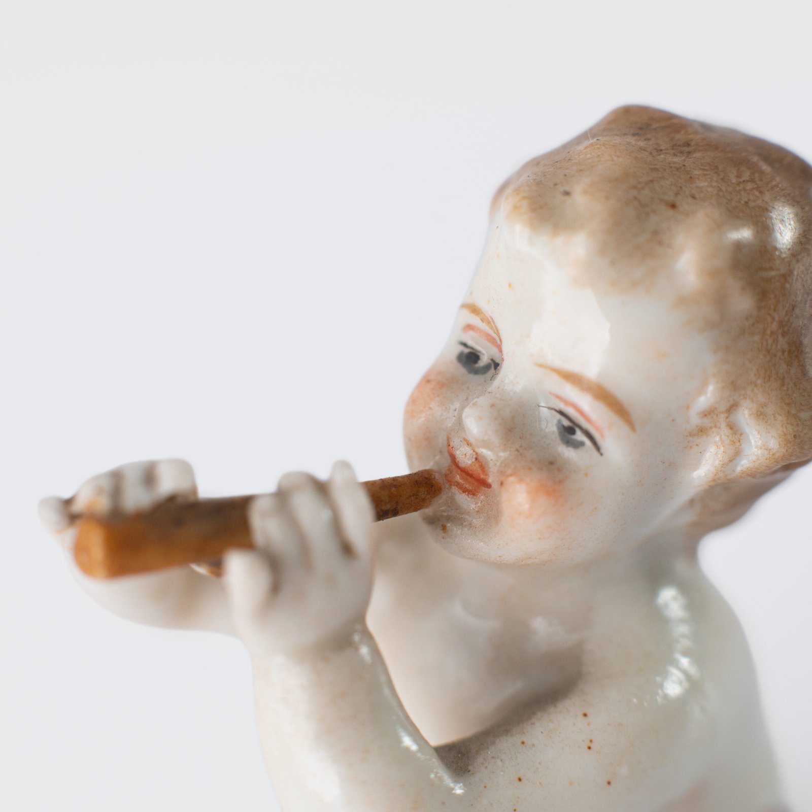Delicate set of four hand-painted porcelain putti musicians crafted by the Höchst manufactory in Germany, circa 1767–1779. Each figure depicts a different musical instrument and bears the distinctive Höchst wheel mark with radiating spokes. Approx. 1.77 × 1.77 × 1.18 in. A fine example of late Rococo artistry.