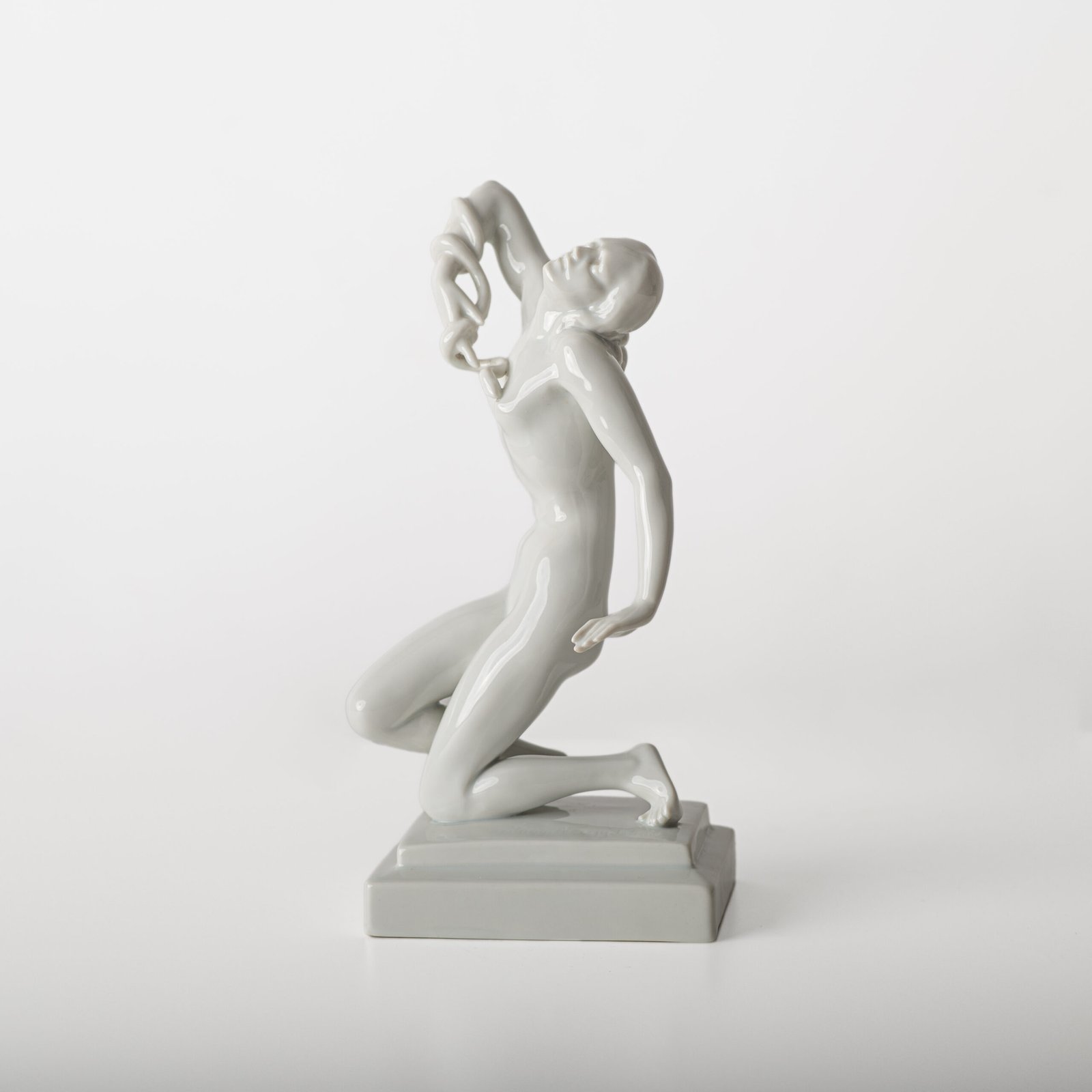 Art Deco porcelain sculpture of Cleopatra kneeling with a snake, in white glazed porcelain by Herend, signed in relief by sculptor Szigethy Nagy István, circa 1930.