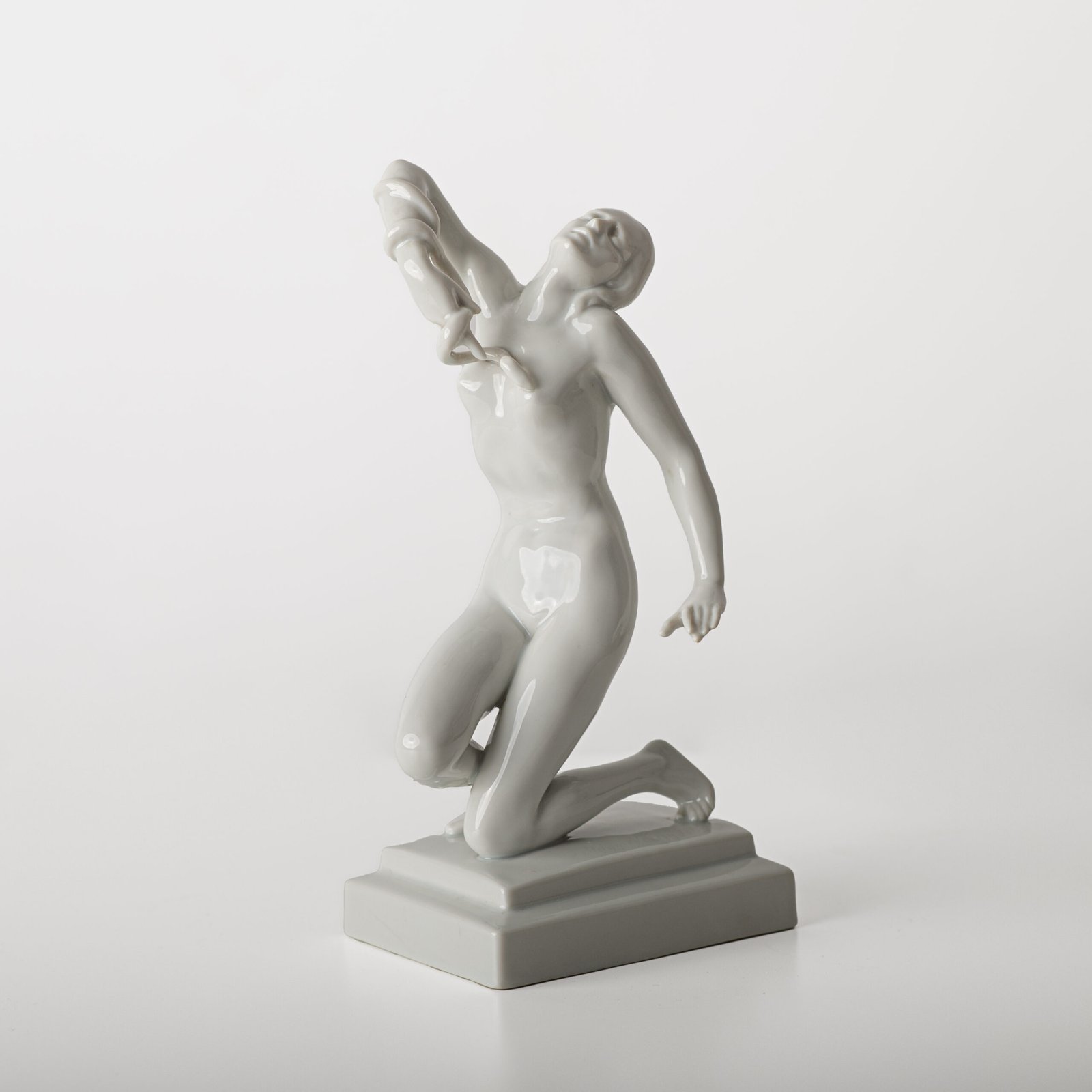 Art Deco porcelain sculpture of Cleopatra kneeling with a snake, in white glazed porcelain by Herend, signed in relief by sculptor Szigethy Nagy István, circa 1930.