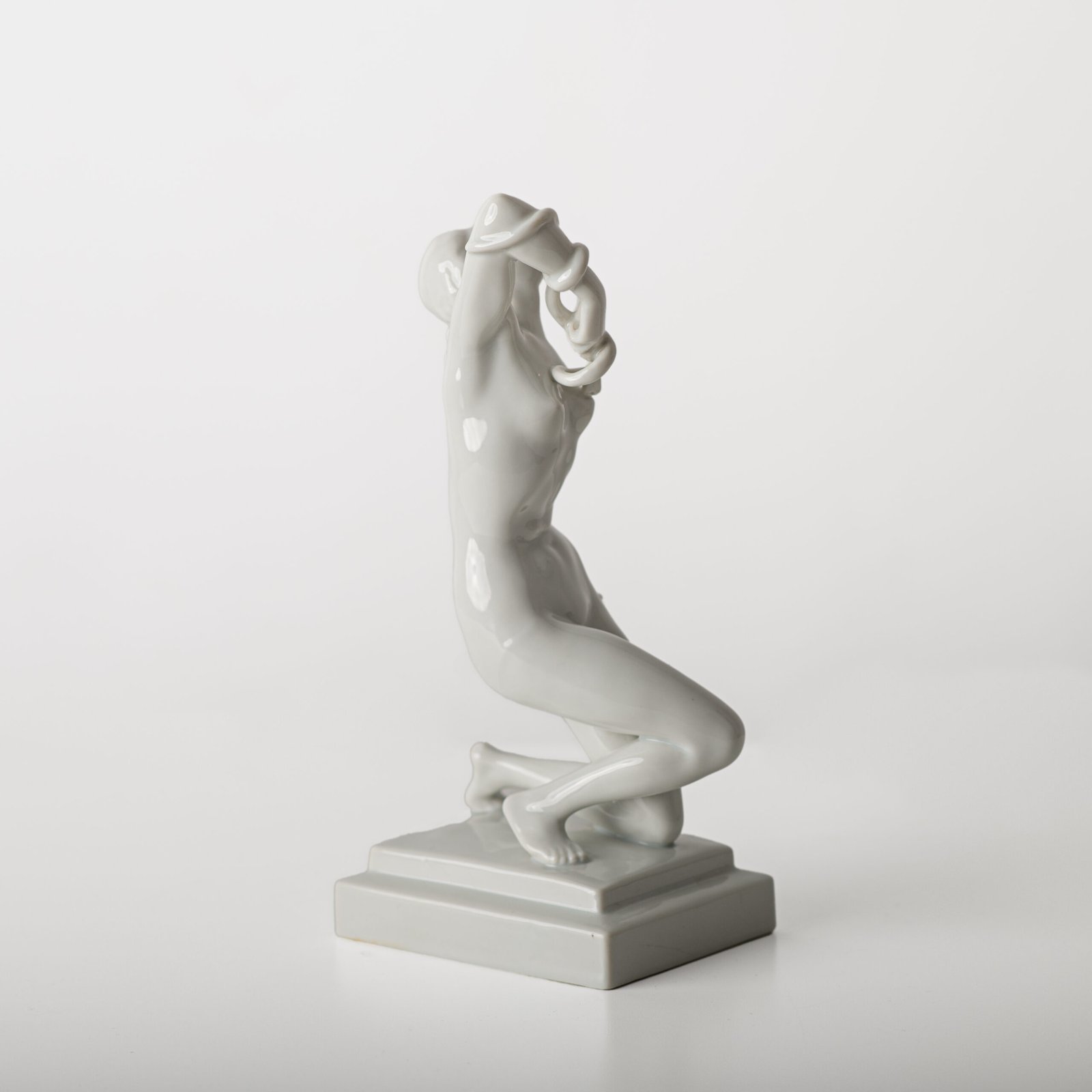 Art Deco porcelain sculpture of Cleopatra kneeling with a snake, in white glazed porcelain by Herend, signed in relief by sculptor Szigethy Nagy István, circa 1930.