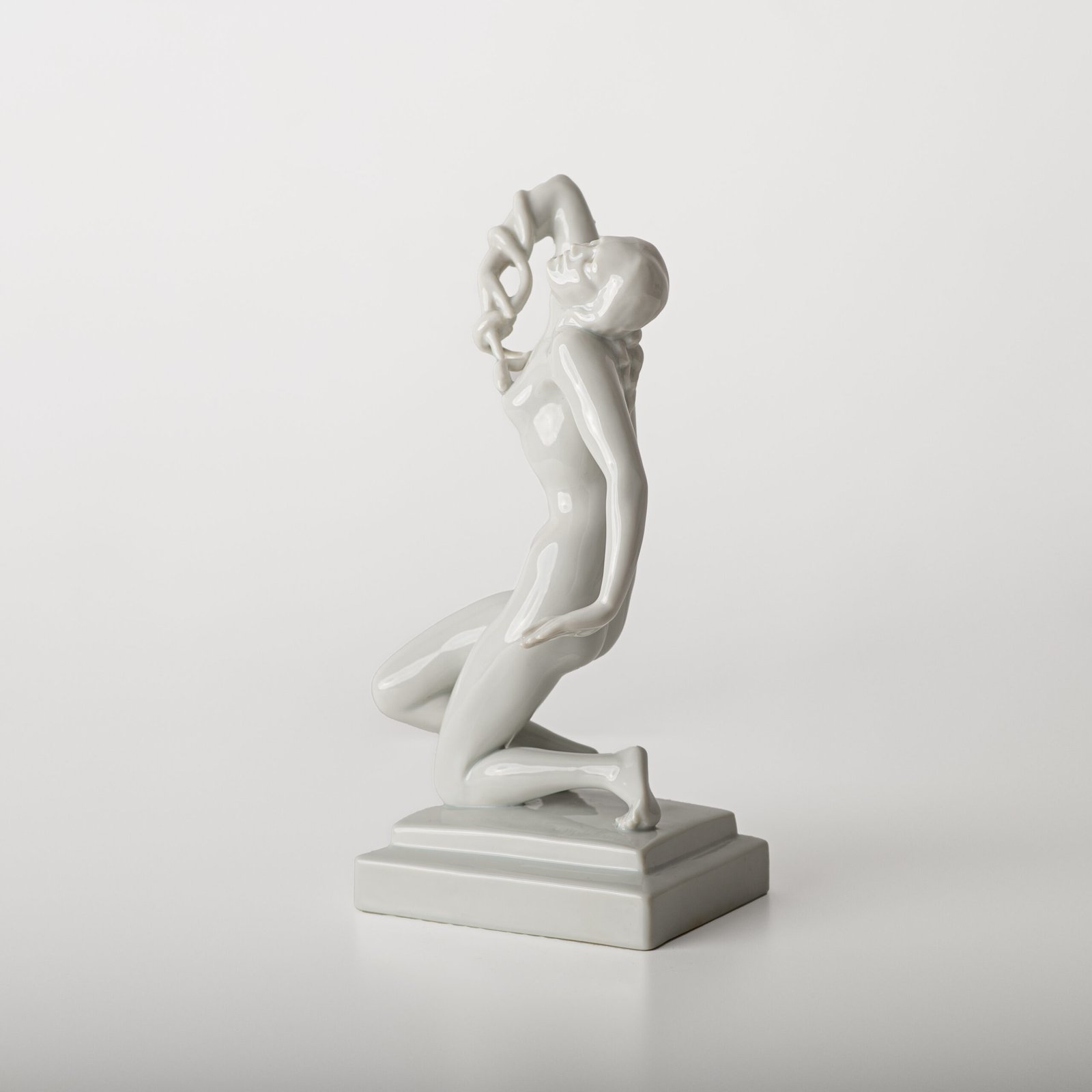 Art Deco porcelain sculpture of Cleopatra kneeling with a snake, in white glazed porcelain by Herend, signed in relief by sculptor Szigethy Nagy István, circa 1930.