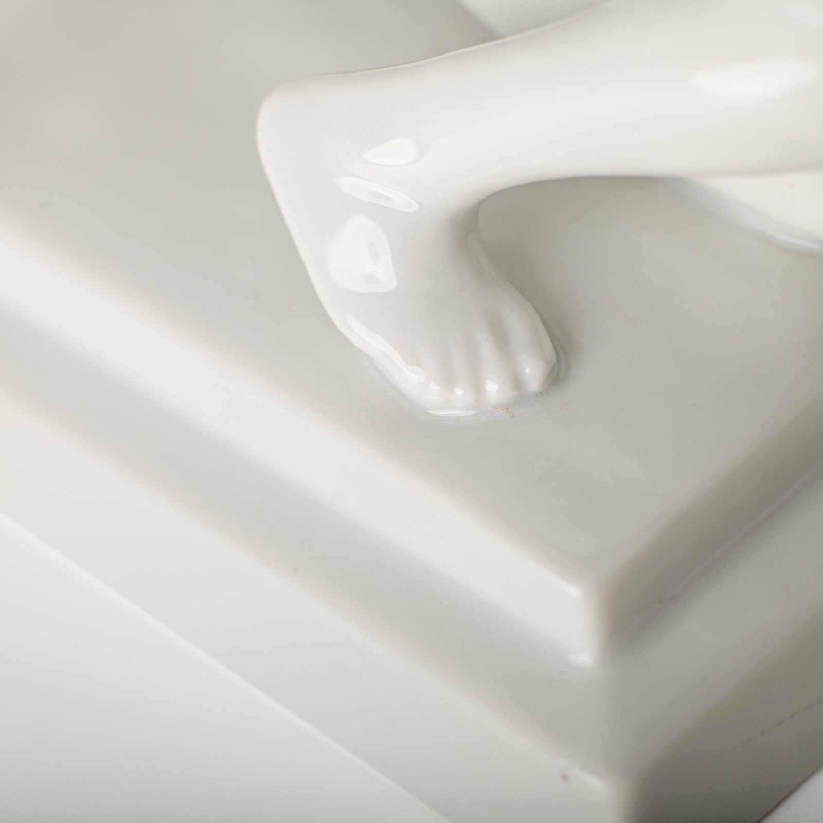 Art Deco porcelain sculpture of Cleopatra kneeling with a snake, in white glazed porcelain by Herend, signed in relief by sculptor Szigethy Nagy István, circa 1930.