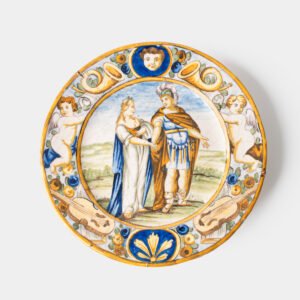 Hand-painted Italian maiolica plate, Deruta or Urbino, late 17th to early 18th century. Depicts Mercury with winged sandals beside a female figure, likely an allegory of Peace, Concord, or Wisdom. Rich Baroque border with cherubs, musical instruments, and cartouches. Tin-glazed earthenware with visible craquelure and minor rim losses.