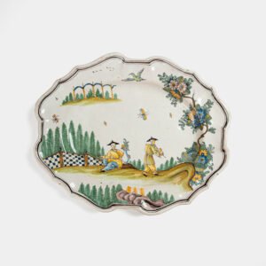 Oval faience plate, France, ca. 1760–1790, attributed to Rouen; tin-glazed earthenware with hand-painted chinoiserie scene in enamel pigments (cobalt, manganese, copper, antimony); figures in stylized garden within manganese-lined scalloped rim; ivory glaze with fine, stable craquelure