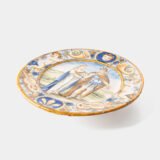Hand-painted Italian maiolica plate, Deruta or Urbino, late 17th to early 18th century. Depicts Mercury with winged sandals beside a female figure, likely an allegory of Peace, Concord, or Wisdom. Rich Baroque border with cherubs, musical instruments, and cartouches. Tin-glazed earthenware with visible craquelure and minor rim losses.
