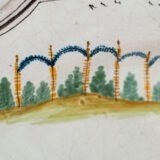 Oval faience plate, France, ca. 1760–1790, attributed to Rouen; tin-glazed earthenware with hand-painted chinoiserie scene in enamel pigments (cobalt, manganese, copper, antimony); figures in stylized garden within manganese-lined scalloped rim; ivory glaze with fine, stable craquelure
