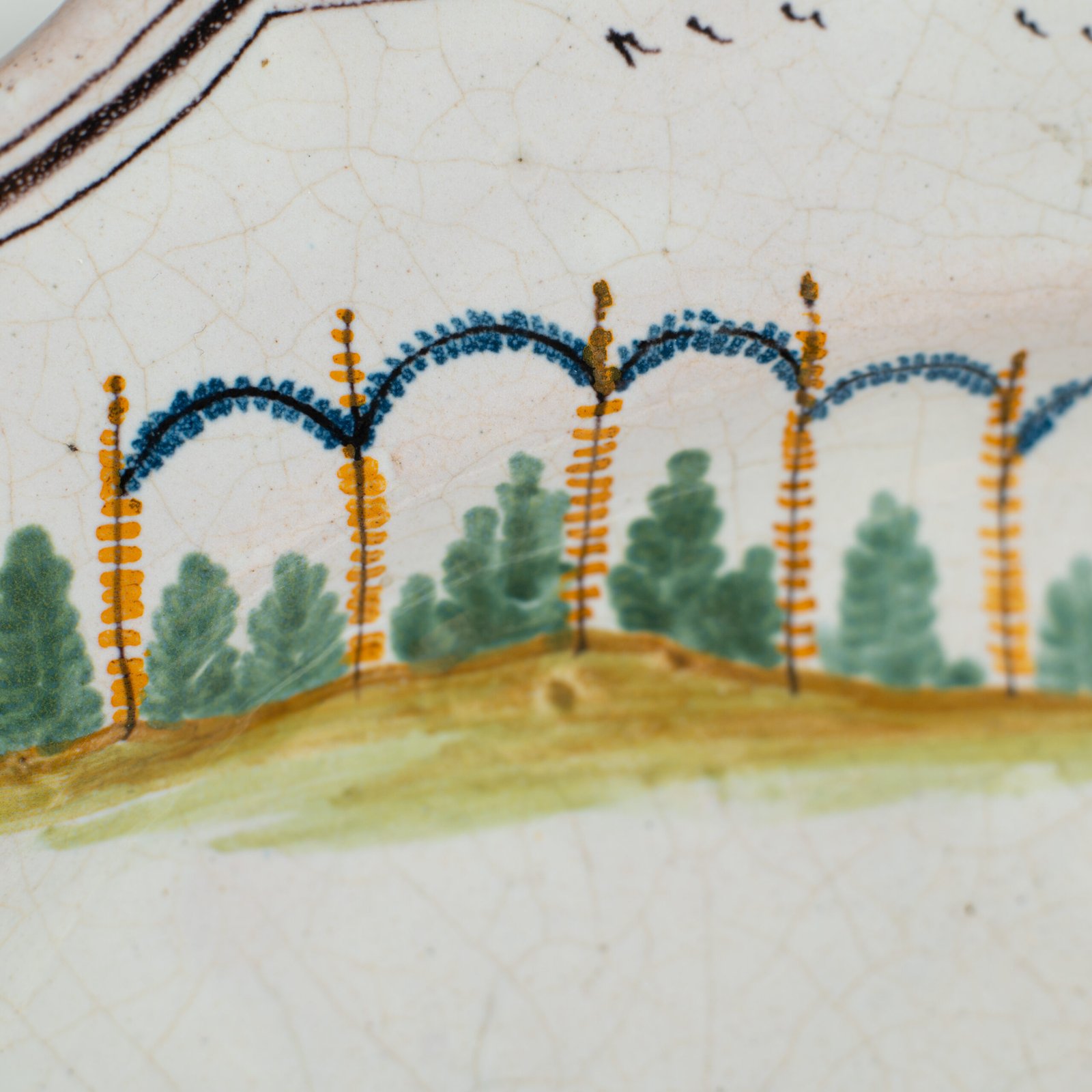 Oval faience plate, France, ca. 1760–1790, attributed to Rouen; tin-glazed earthenware with hand-painted chinoiserie scene in enamel pigments (cobalt, manganese, copper, antimony); figures in stylized garden within manganese-lined scalloped rim; ivory glaze with fine, stable craquelure
