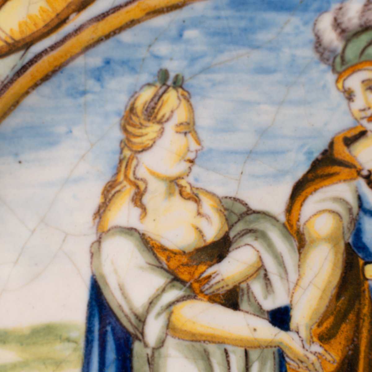 Hand-painted Italian maiolica plate, Deruta or Urbino, late 17th to early 18th century. Depicts Mercury with winged sandals beside a female figure, likely an allegory of Peace, Concord, or Wisdom. Rich Baroque border with cherubs, musical instruments, and cartouches. Tin-glazed earthenware with visible craquelure and minor rim losses.