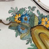 Oval faience plate, France, ca. 1760–1790, attributed to Rouen; tin-glazed earthenware with hand-painted chinoiserie scene in enamel pigments (cobalt, manganese, copper, antimony); figures in stylized garden within manganese-lined scalloped rim; ivory glaze with fine, stable craquelure