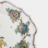 Oval faience plate, France, ca. 1760–1790, attributed to Rouen; tin-glazed earthenware with hand-painted chinoiserie scene in enamel pigments (cobalt, manganese, copper, antimony); figures in stylized garden within manganese-lined scalloped rim; ivory glaze with fine, stable craquelure