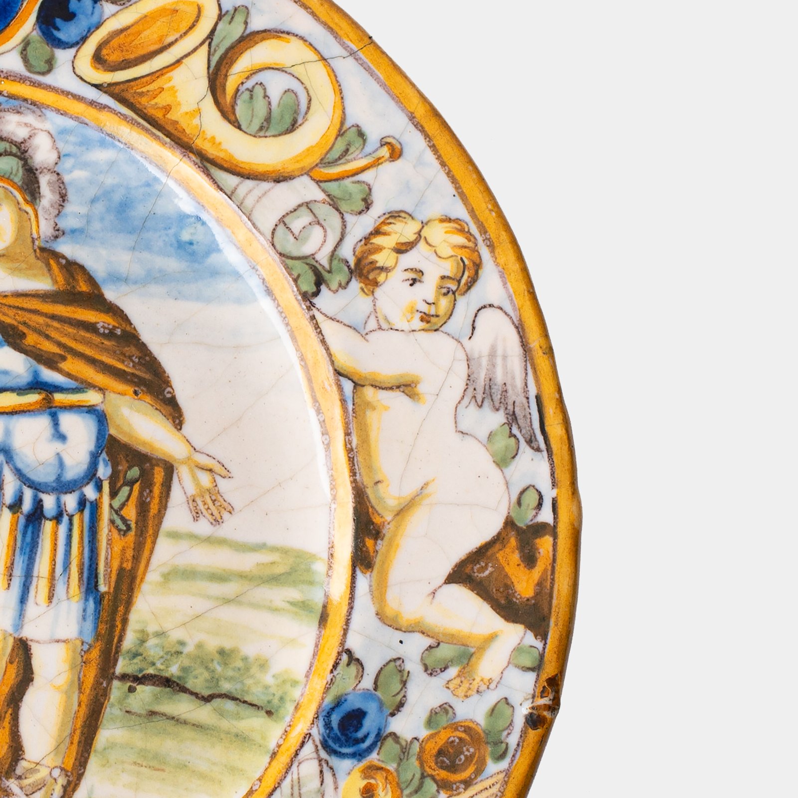 Hand-painted Italian maiolica plate, Deruta or Urbino, late 17th to early 18th century. Depicts Mercury with winged sandals beside a female figure, likely an allegory of Peace, Concord, or Wisdom. Rich Baroque border with cherubs, musical instruments, and cartouches. Tin-glazed earthenware with visible craquelure and minor rim losses.