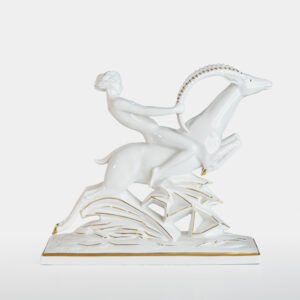 Glazed white porcelain sculpture signed by Max Hermann Fritz and produced by Hutschenreuther Selb between 1925 and 1935. Depicts a nude female figure riding a leaping ibex, with hand-applied gilding on the horns, eyes, hooves, and base. German Art Deco style.