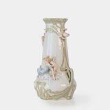 Art Nouveau porcelain vase by Karl Ens, circa 1900, featuring a sculptural composition in high relief with a maiden and cherub, hand-painted with floral details and highlighted with gilding. Marked “KVE” on the base.