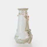 Art Nouveau porcelain vase by Karl Ens, circa 1900, featuring a sculptural composition in high relief with a maiden and cherub, hand-painted with floral details and highlighted with gilding. Marked “KVE” on the base.