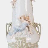 Art Nouveau porcelain vase by Karl Ens, circa 1900, featuring a sculptural composition in high relief with a maiden and cherub, hand-painted with floral details and highlighted with gilding. Marked “KVE” on the base.
