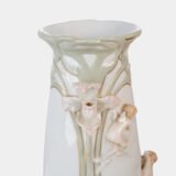 Art Nouveau porcelain vase by Karl Ens, circa 1900, featuring a sculptural composition in high relief with a maiden and cherub, hand-painted with floral details and highlighted with gilding. Marked “KVE” on the base.