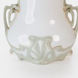Art Nouveau porcelain vase by Karl Ens, circa 1900, featuring a sculptural composition in high relief with a maiden and cherub, hand-painted with floral details and highlighted with gilding. Marked “KVE” on the base.