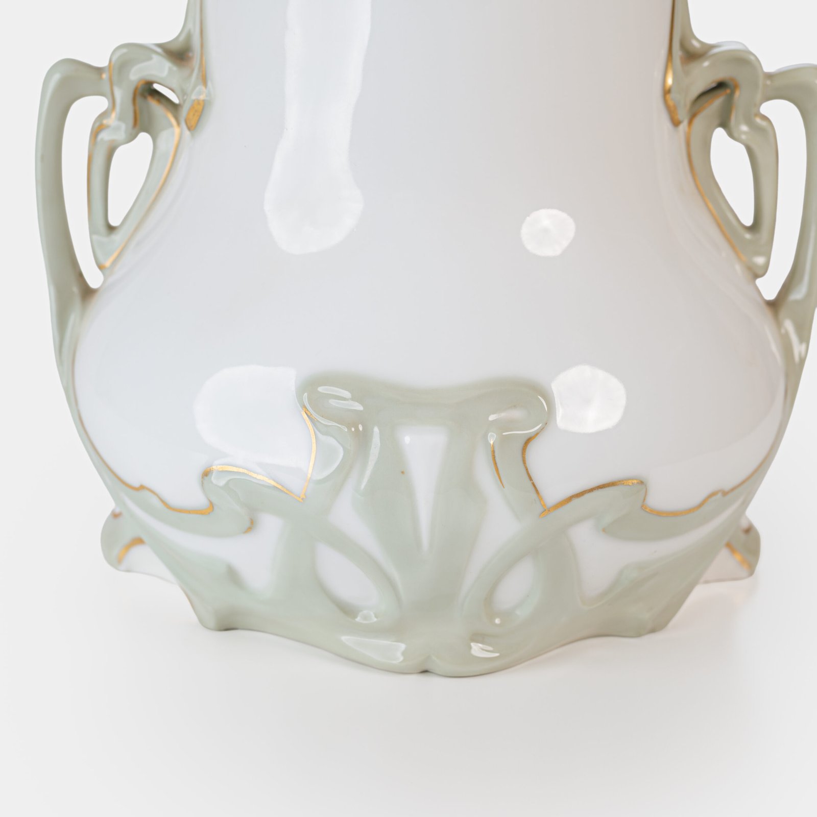 Art Nouveau porcelain vase by Karl Ens, circa 1900, featuring a sculptural composition in high relief with a maiden and cherub, hand-painted with floral details and highlighted with gilding. Marked “KVE” on the base.