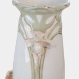 Art Nouveau porcelain vase by Karl Ens, circa 1900, featuring a sculptural composition in high relief with a maiden and cherub, hand-painted with floral details and highlighted with gilding. Marked “KVE” on the base.