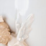 Art Nouveau porcelain vase by Karl Ens, circa 1900, featuring a sculptural composition in high relief with a maiden and cherub, hand-painted with floral details and highlighted with gilding. Marked “KVE” on the base.