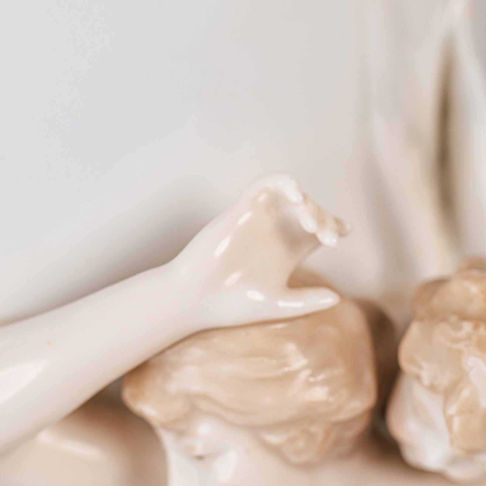Art Nouveau porcelain vase by Karl Ens, circa 1900, featuring a sculptural composition in high relief with a maiden and cherub, hand-painted with floral details and highlighted with gilding. Marked “KVE” on the base.