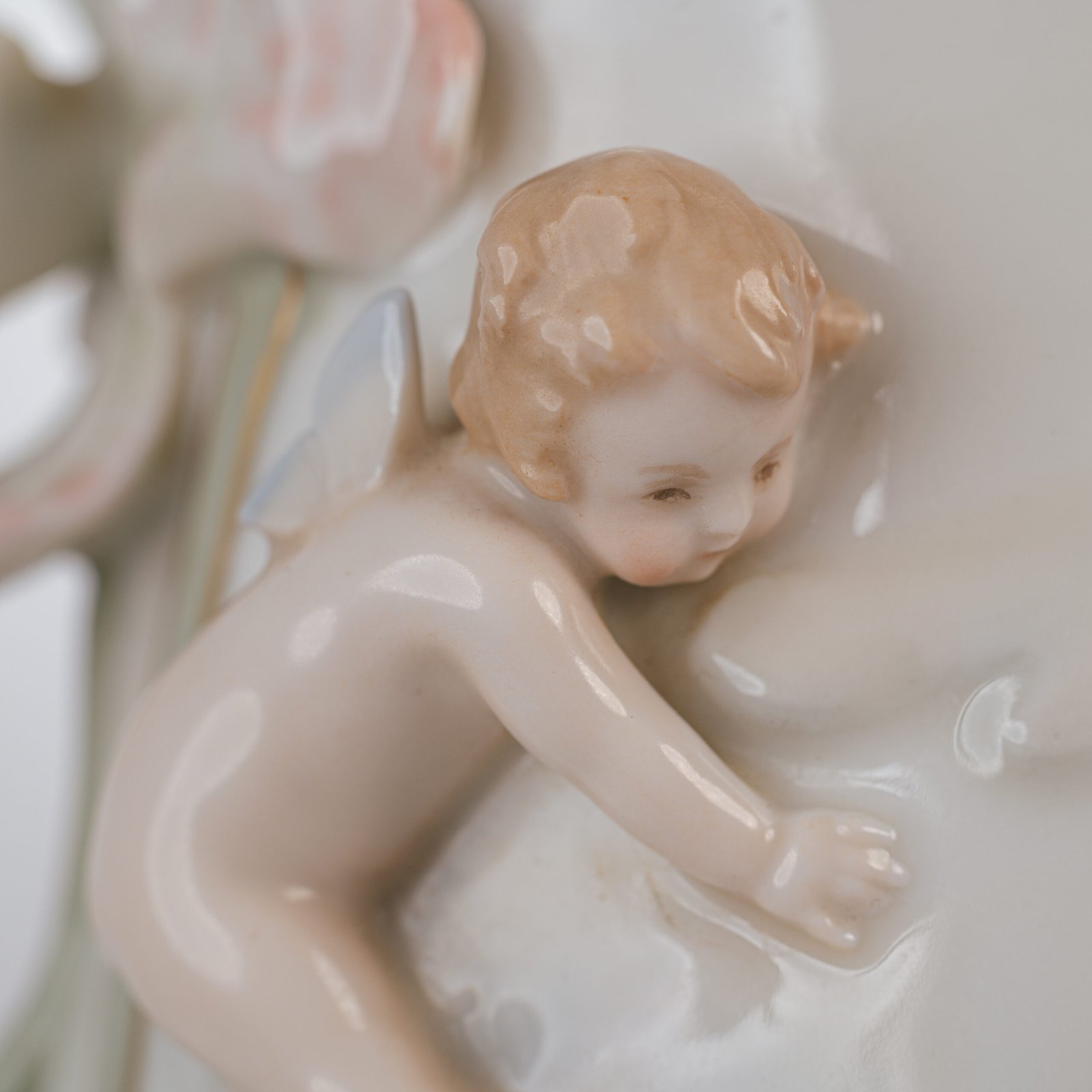 Art Nouveau porcelain vase by Karl Ens, circa 1900, featuring a sculptural composition in high relief with a maiden and cherub, hand-painted with floral details and highlighted with gilding. Marked “KVE” on the base.