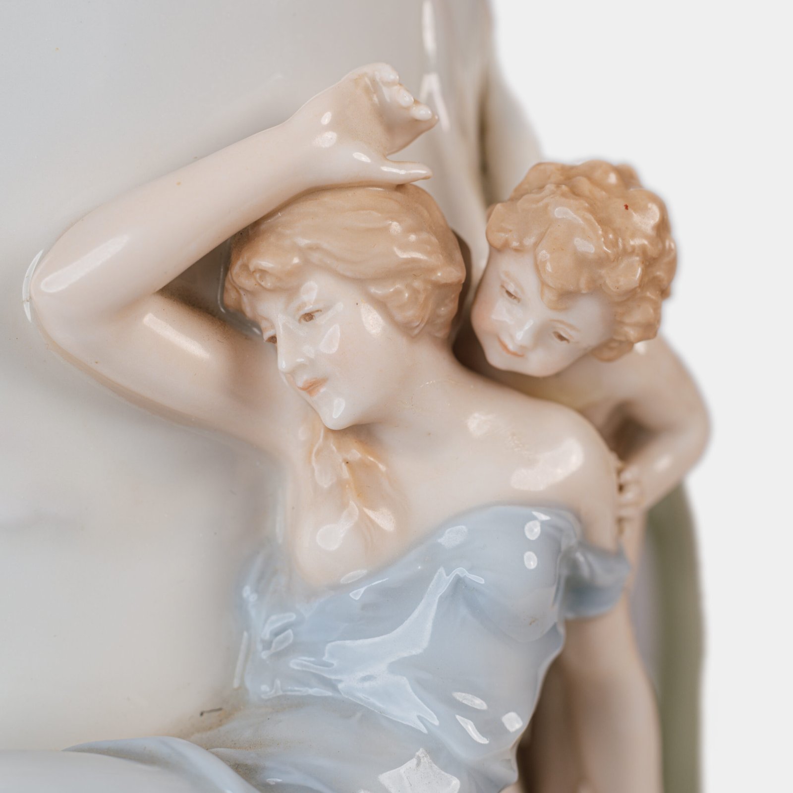 Art Nouveau porcelain vase by Karl Ens, circa 1900, featuring a sculptural composition in high relief with a maiden and cherub, hand-painted with floral details and highlighted with gilding. Marked “KVE” on the base.