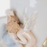 Art Nouveau porcelain vase by Karl Ens, circa 1900, featuring a sculptural composition in high relief with a maiden and cherub, hand-painted with floral details and highlighted with gilding. Marked “KVE” on the base.