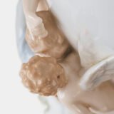 Art Nouveau porcelain vase by Karl Ens, circa 1900, featuring a sculptural composition in high relief with a maiden and cherub, hand-painted with floral details and highlighted with gilding. Marked “KVE” on the base.