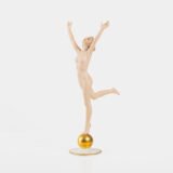 Karl Tutter porcelain figurine “Sonnenkind” – Art Deco sculpture by Hutschenreuther Germany, c.1935–1940 Art Deco porcelain figurine titled “Sonnenkind” (“Sun Child”), modeled by Karl Tutter for Hutschenreuther ca. 1935–1940. Depicts a nude young woman balancing on a golden sphere, arms extended in a dynamic pose. White porcelain with a matte pinkish flesh-tone finish, painted facial features, and satin brown hair. Gilded accents on the sphere and base. Rare signed version with circular base and gold trim.