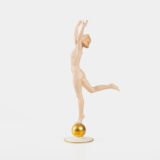 Karl Tutter porcelain figurine “Sonnenkind” – Art Deco sculpture by Hutschenreuther Germany, c.1935–1940 Art Deco porcelain figurine titled “Sonnenkind” (“Sun Child”), modeled by Karl Tutter for Hutschenreuther ca. 1935–1940. Depicts a nude young woman balancing on a golden sphere, arms extended in a dynamic pose. White porcelain with a matte pinkish flesh-tone finish, painted facial features, and satin brown hair. Gilded accents on the sphere and base. Rare signed version with circular base and gold trim.