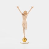 Karl Tutter porcelain figurine “Sonnenkind” – Art Deco sculpture by Hutschenreuther Germany, c.1935–1940 Art Deco porcelain figurine titled “Sonnenkind” (“Sun Child”), modeled by Karl Tutter for Hutschenreuther ca. 1935–1940. Depicts a nude young woman balancing on a golden sphere, arms extended in a dynamic pose. White porcelain with a matte pinkish flesh-tone finish, painted facial features, and satin brown hair. Gilded accents on the sphere and base. Rare signed version with circular base and gold trim.
