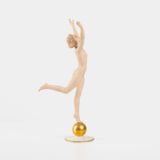 Karl Tutter porcelain figurine “Sonnenkind” – Art Deco sculpture by Hutschenreuther Germany, c.1935–1940 Art Deco porcelain figurine titled “Sonnenkind” (“Sun Child”), modeled by Karl Tutter for Hutschenreuther ca. 1935–1940. Depicts a nude young woman balancing on a golden sphere, arms extended in a dynamic pose. White porcelain with a matte pinkish flesh-tone finish, painted facial features, and satin brown hair. Gilded accents on the sphere and base. Rare signed version with circular base and gold trim.