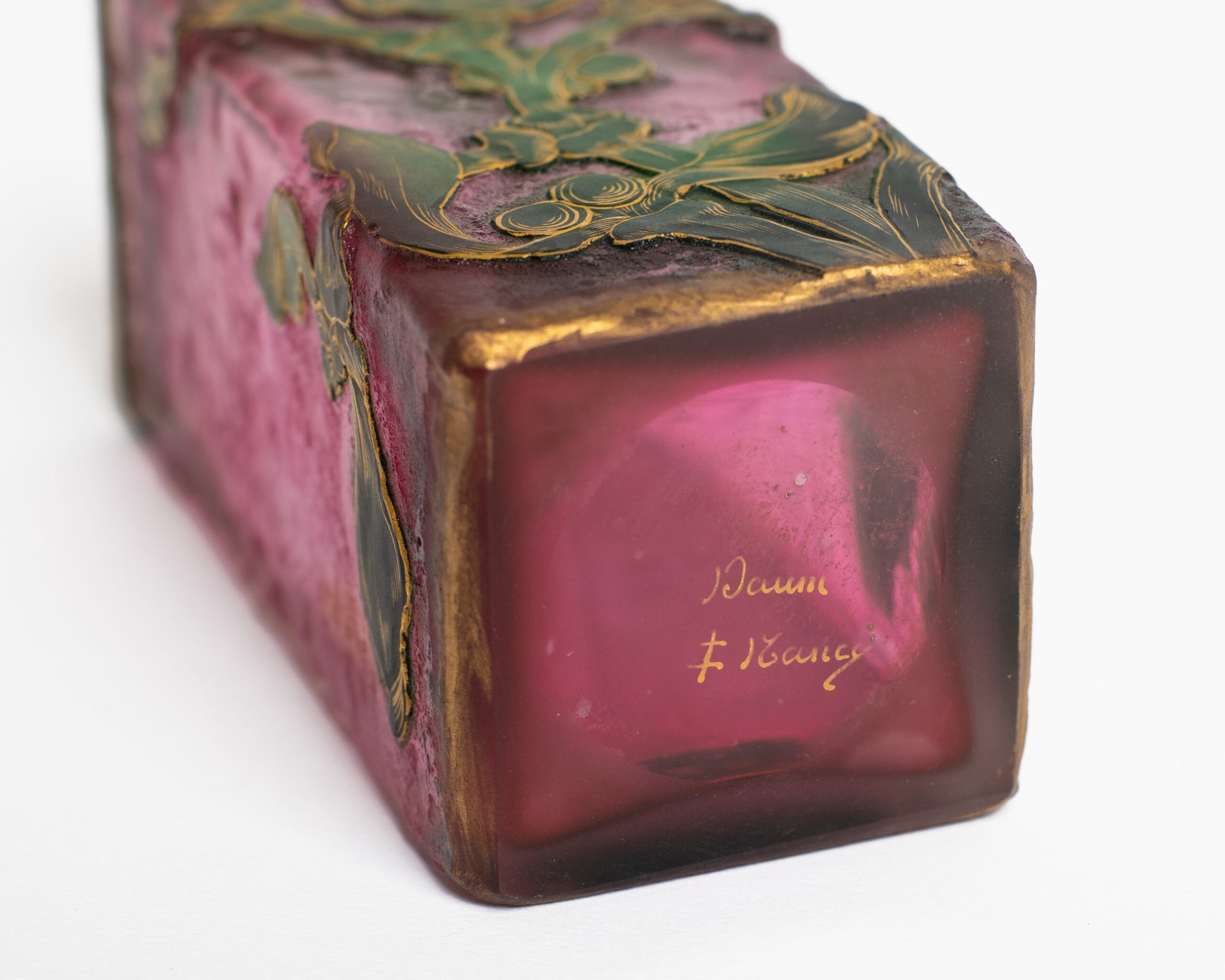 Daum (Nancy) Art Nouveau vase in pink acid-etched (frosted) glass with painted green floral decoration and gold enamel details; signed in gold with the Cross of Lorraine. Dimensions: 4.52 in (11.5 cm) high × 2.16 in (5.5 cm) wide × 2.16 in (5.5 cm) deep. Excellent condition, no chips; representative example of French art-glass production, c. 1900–1920, suitable for collections and interior design projects.